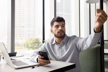 Working on freelance. Busy generation z man engaged in remote work online using notebook pc...