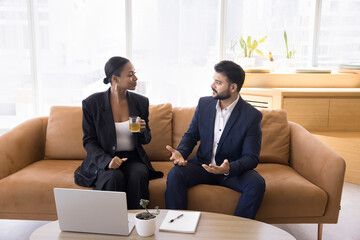 Collaborative brainstorming. Two diverse businesspeople colleagues enjoy tea during decision making...