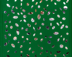 Green wooden shield with holes.