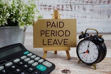 Paid Period Leave text with alarm clock and calculator on wooden background