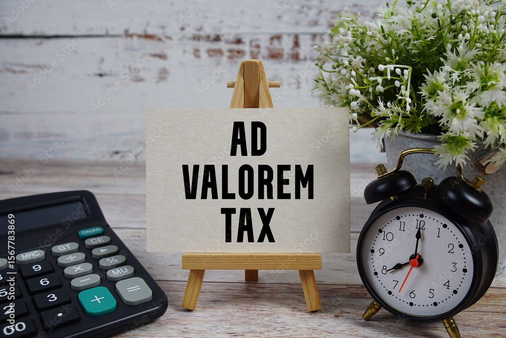 Poster ad valorem tax text with alarm clock and calculator on wooden background