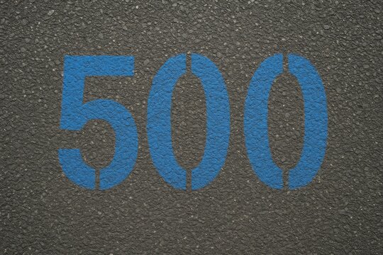 A blue-painted number 500 is displayed on the sidewalk surface
