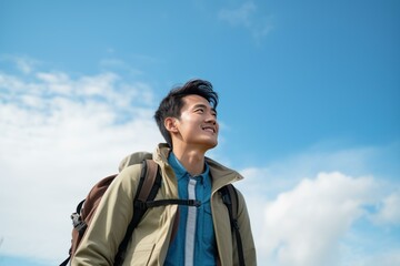 Young male hiker smiling and enjoying hiking in nature under blue sky