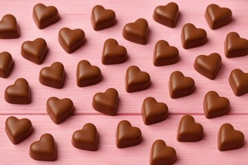 Fototapeta premium Pink wooden table with heart-shaped chocolate confections