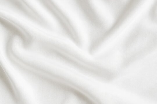 Elegant white cotton fabric showcasing smooth wave patterns on a neutral background for product display or advertising. Top-down perspective or flat lay style.