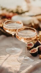 Two coupe glasses filled with rosé champagne