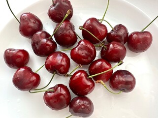 Fresh farm-grown strawberries and cherries on a white background. Organic seasonal berries, handpicked and washed, close-up in natural daylight.