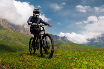 Male athlete cyclist in helmet and protective mask outdoors. MTB rider in mountainous terrain...