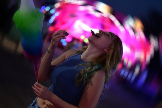 Young woman having a good time at a funfair at night