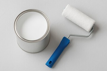 Obraz premium Using a white water-based paint can and a medium-sized roller, prepare tools for DIY ceiling and wall whitewashing.