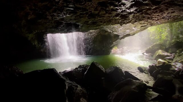Waterfall Pouring Through Cave Opening &ndash; Tropical Rainforest Scene with Rock Arch, Mist, and Lush Surroundings at Natural Bridge, Springbrook National Park, Gold Coast Hinterland
