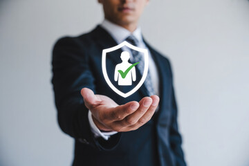 Businessman presents a shield with a person and checkmark