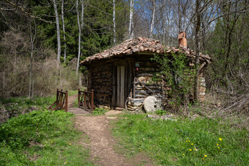 An old mill for grinding flour made on the road through the forest.