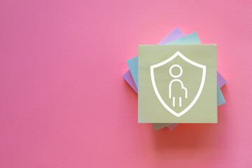Pregnancy health and wellness protection concept.,A sticky note with a mother and child protection symbol on pink background with copyspace.,Idea for pregnant woman protecting,prenatal care.