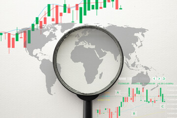 Global stock market analysis. A magnifying glass over a world map with financial candlestick...