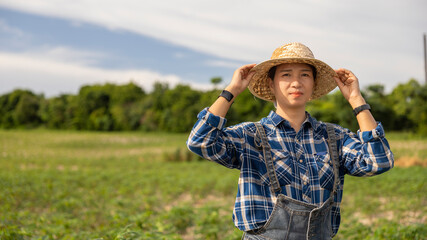 Woman Adjusts Hat in Sunny Farm Landscape