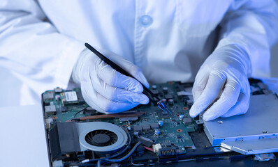 Technician Repairs Laptop Motherboard in a Lab