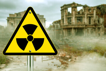 Radiation warning sign in front of destroyed abandoned buildings, symbolizing nuclear disaster,...