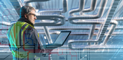 Man ventilation engineer. Builder with laptop under vents shafts. Air handling unit maintenance....