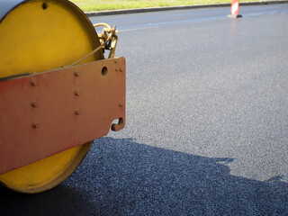 Asphalt paver roller close-up. Road construction machine. Hot asphalt roller press. Road...