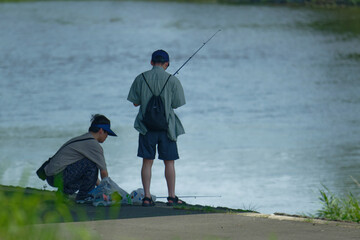 Boys fishing on the riverbank