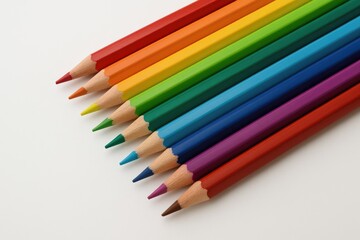 Fototapeta premium Color pencils arranged on a plain white surface, isolated