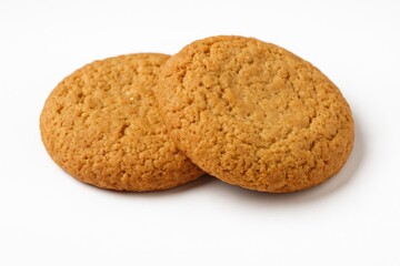 Close-up of crispy cookies displayed against a plain white backdrop. Tasty golden-brown biscuits perfect for a wholesome treat. Classic homemade sweet pastry