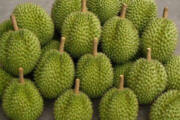 Detailed view of a pile of ripe durians resting on the ground