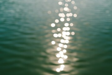 Diffuse sunlight shimmering on a serene lake surface in a tranquil park