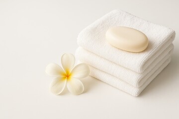 Clean white towels with soap on a plain white surface