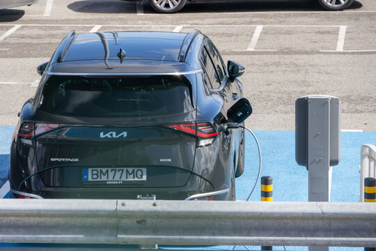 Black kia sportage phev suv charging at public charging station
