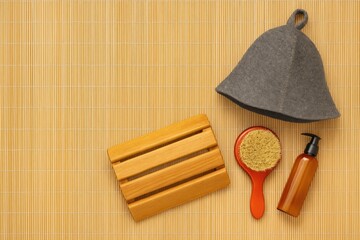 Comfort accessories for relaxation: headrest, felt hat, and beauty products on a mat with empty space