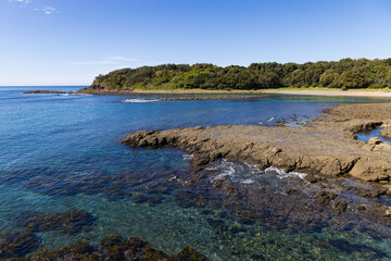 The beautifully scenic Boneyard surfing cove located near Cathedral Rocks on the South Coast. Captured from a rock platform on a blue sky sunny day.