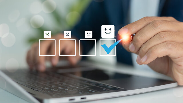 Close-up of hand selecting happy face icon with blue check mark on digital feedback survey, representing customer satisfaction and user experience rating.