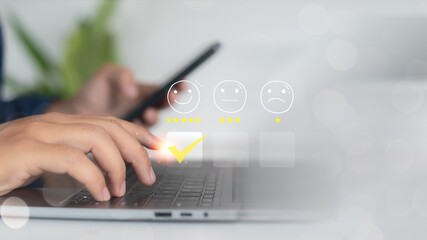 Close-up of hand selecting smiley face rating icon with star ratings on digital survey, representing customer feedback, online review, and user satisfaction.