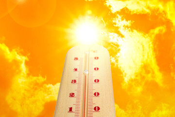 High temperature on thermometer against orange sky on sunny day. Hot summer weather
