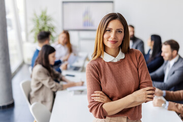 Portrait of confident businesswoman standing at conference room during meeting.