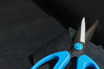 Scissors and a piece of leather, leatherworking top view background.