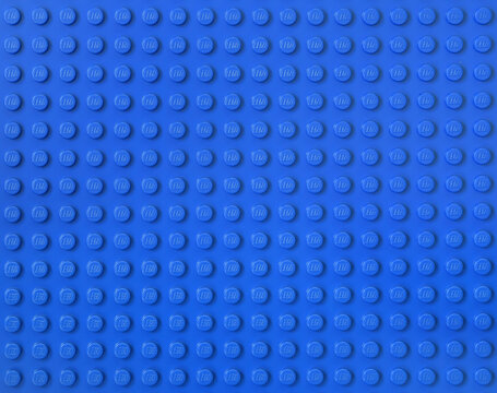 Lego blue new baseplate with rows of round knots to assembly plastic bricks from popular toy brand. Editorial illustrative image of popular children plastic toy.