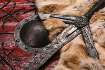 Old long medieval two handed knight warrior sword and viking wooden shield with ancient runes and...