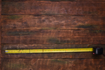 Construction tape measure on carpenter or builder table top view background.