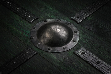 Old green Viking shield with metal umbo texture background.
