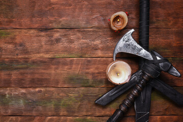 Old long medieval two handed knight warrior sword and battle axe on ancient table flat lay...