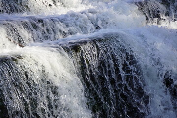 Close-up view of cascading step waterfalls in The Peak District, England. Serene natural beauty captured in detail.
