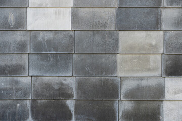 Modern textures create visual interest on a weathered stone wall in soft afternoon light near an...
