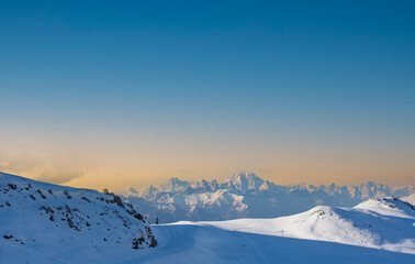 the sun sets behind the mountains on a beautiful winter day