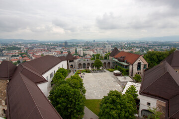 An expansive elevated view looks down upon the courtyard and buildings of Ljubljana Castle, with the sprawling city of Ljubljana