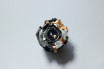 The black inner casing of a camera lens being disassembled, there is optical glass, flexible track,...