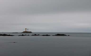 A dramatic black and white image of lighthouses on islands surrounded by the ocean