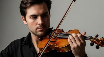 Young caucasian male playing violin with focused expression
